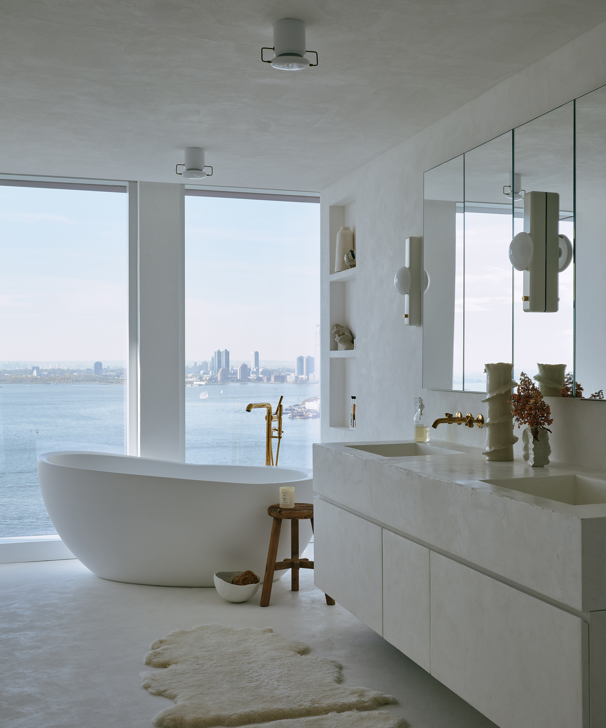a master bathroom with a stand alone tub and a floating concrete vanity