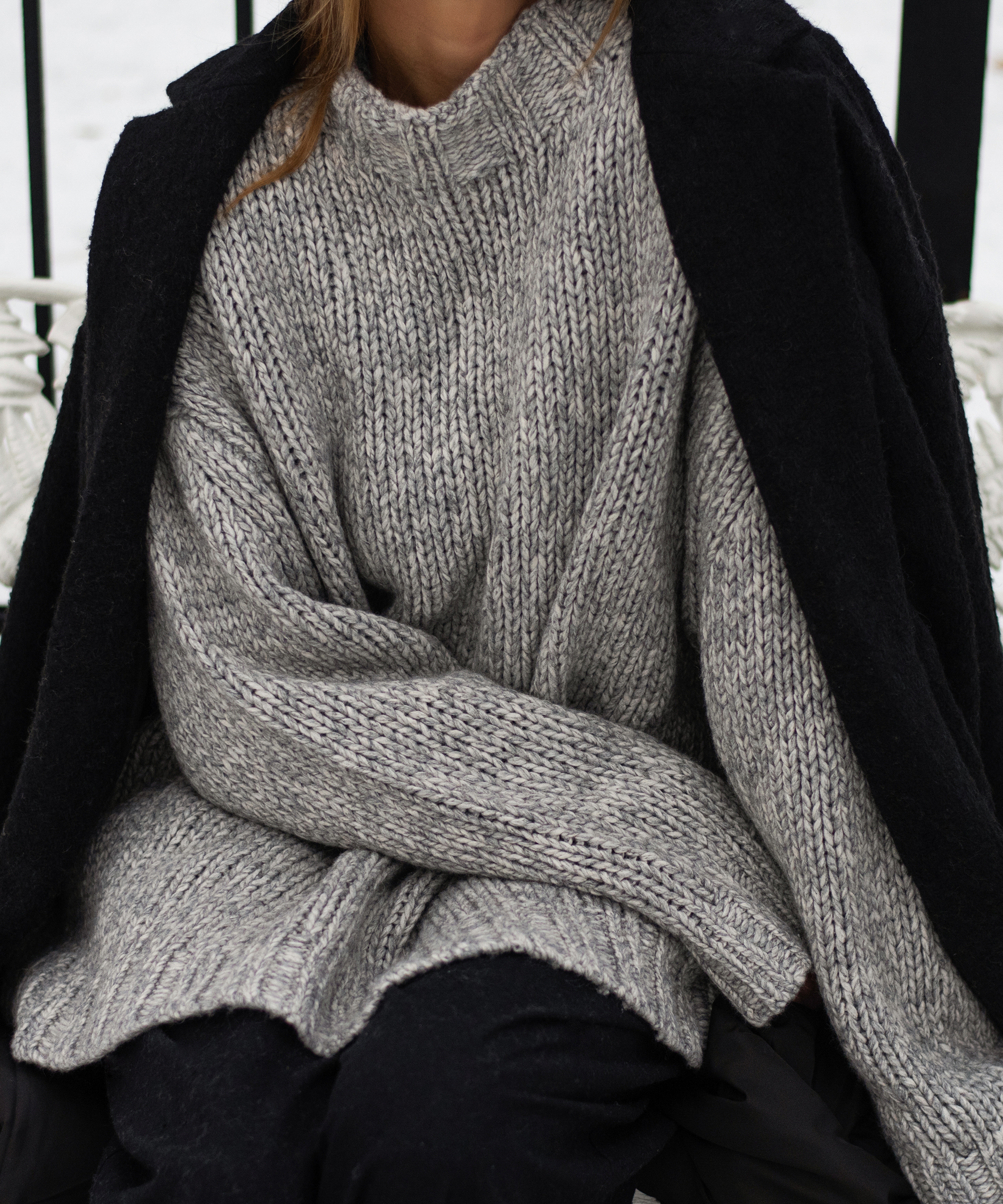 Moritz Mockneck Pullover in grey with a black coat over a woman's shoulders