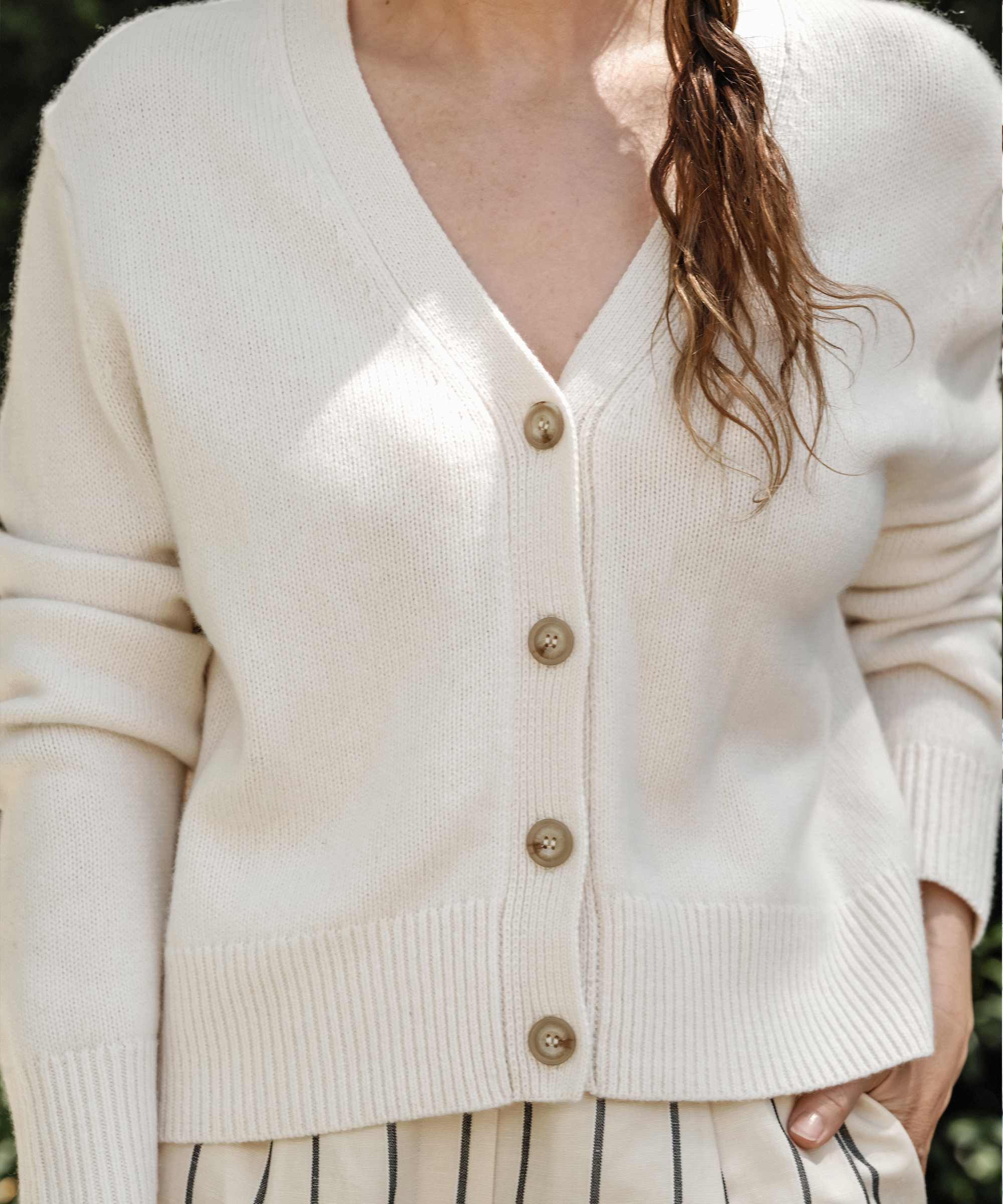 a detail photo of jenni wearing an ivory cardigan