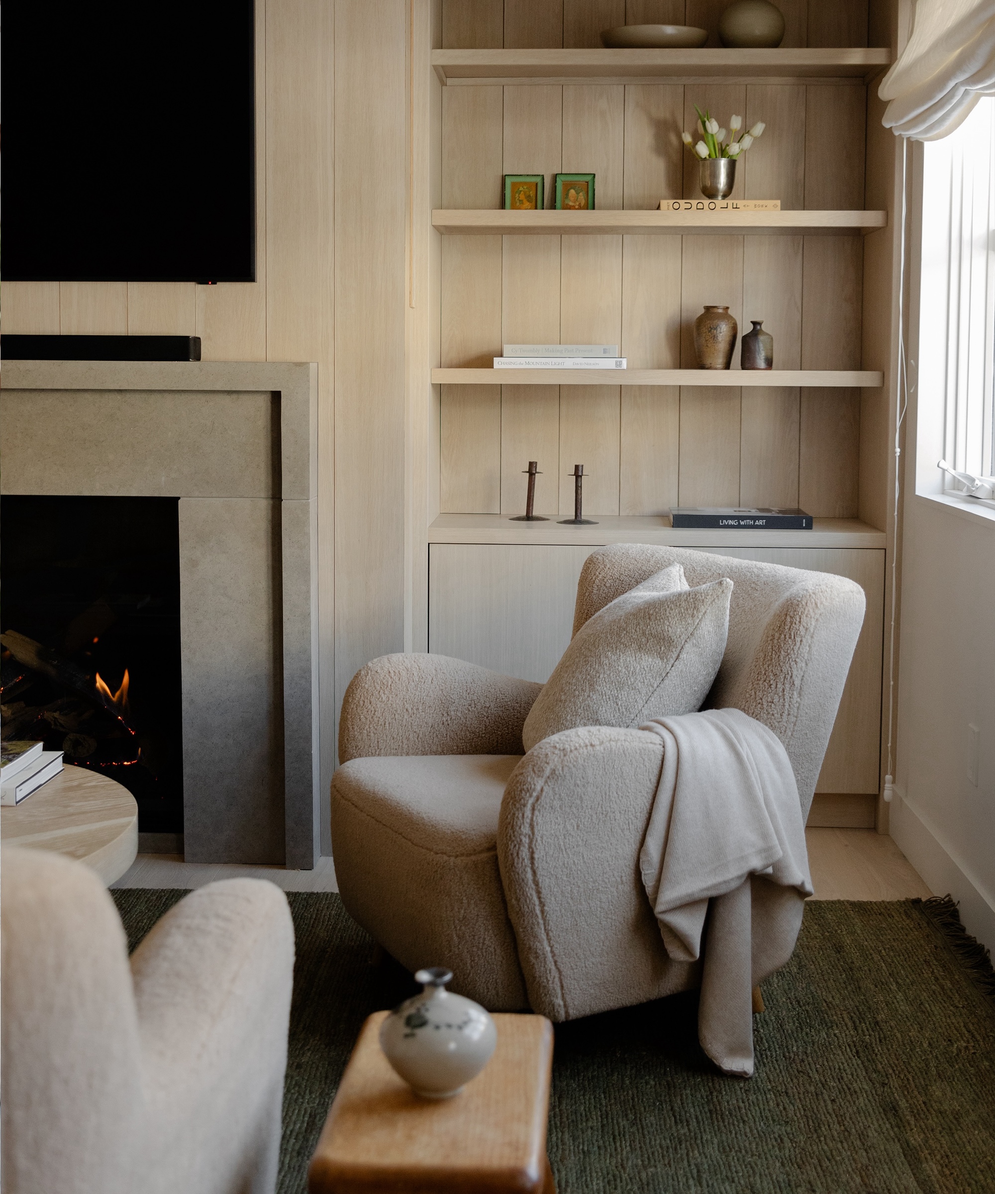 aspen accent chair with a throw and pillow in front of a styled bookcase in a family room