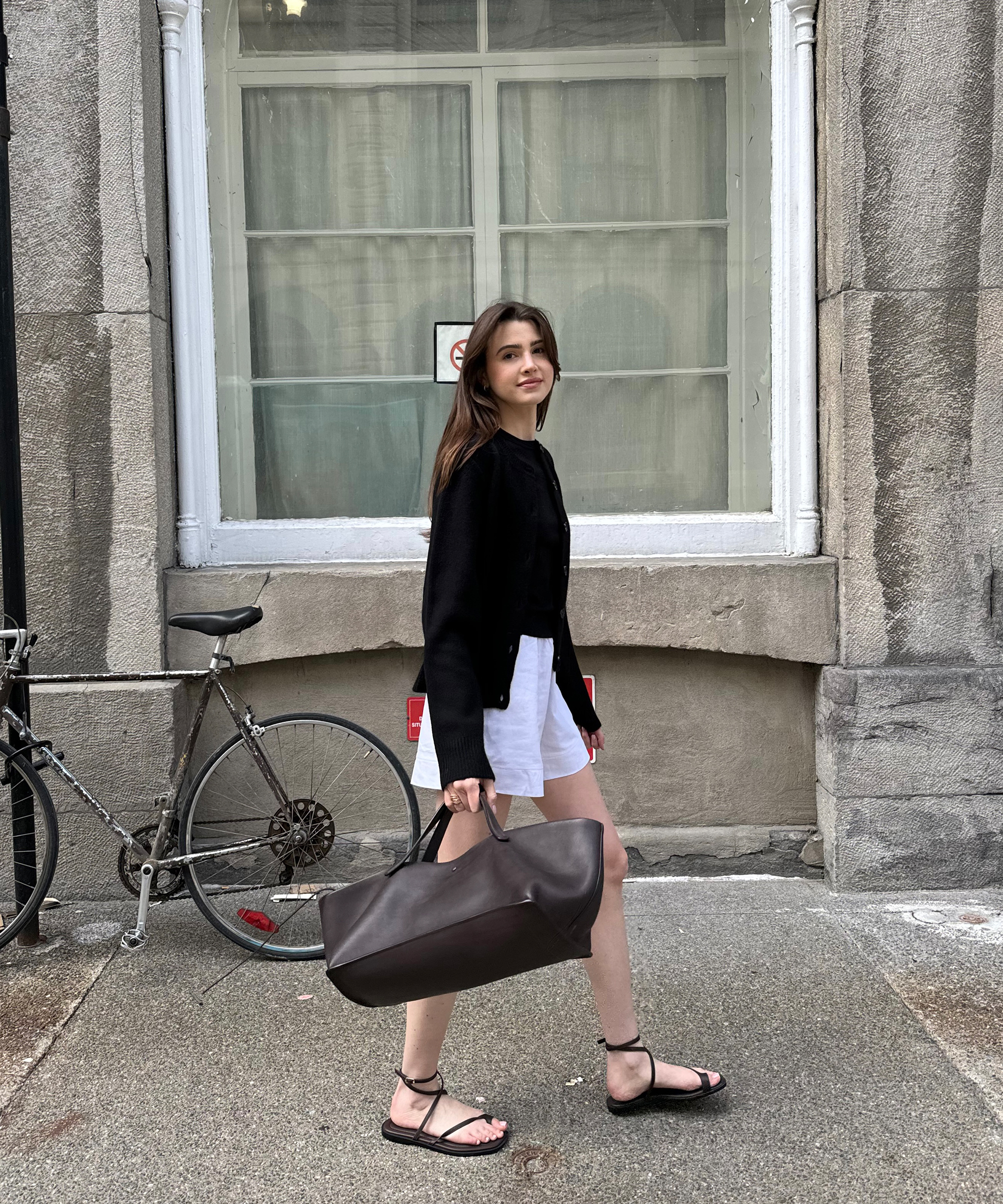 anna-porte-in-uniform-black-cooper-cardigan-white-shorts-walking