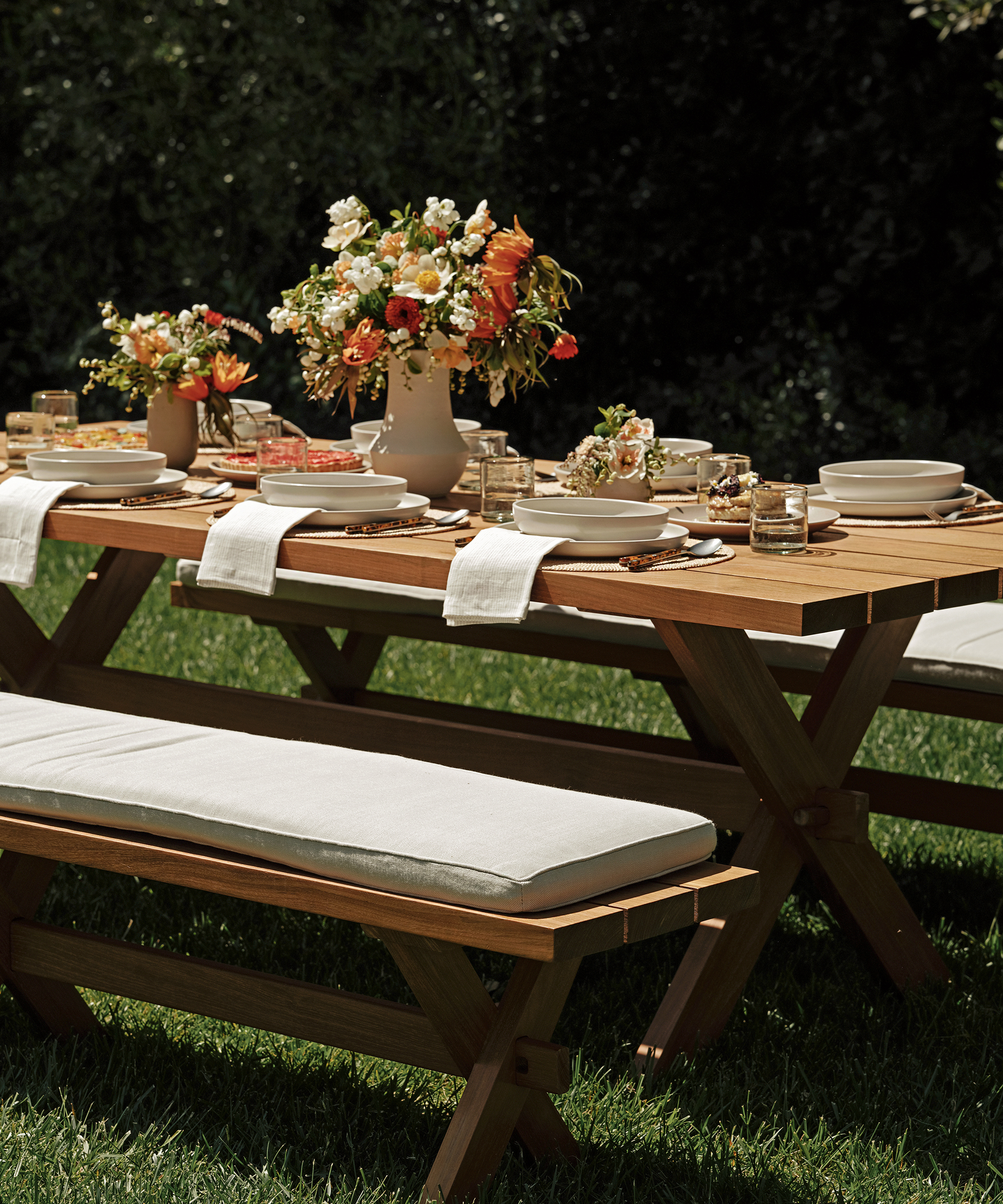 an outdoor dining table and dining bench in the grass