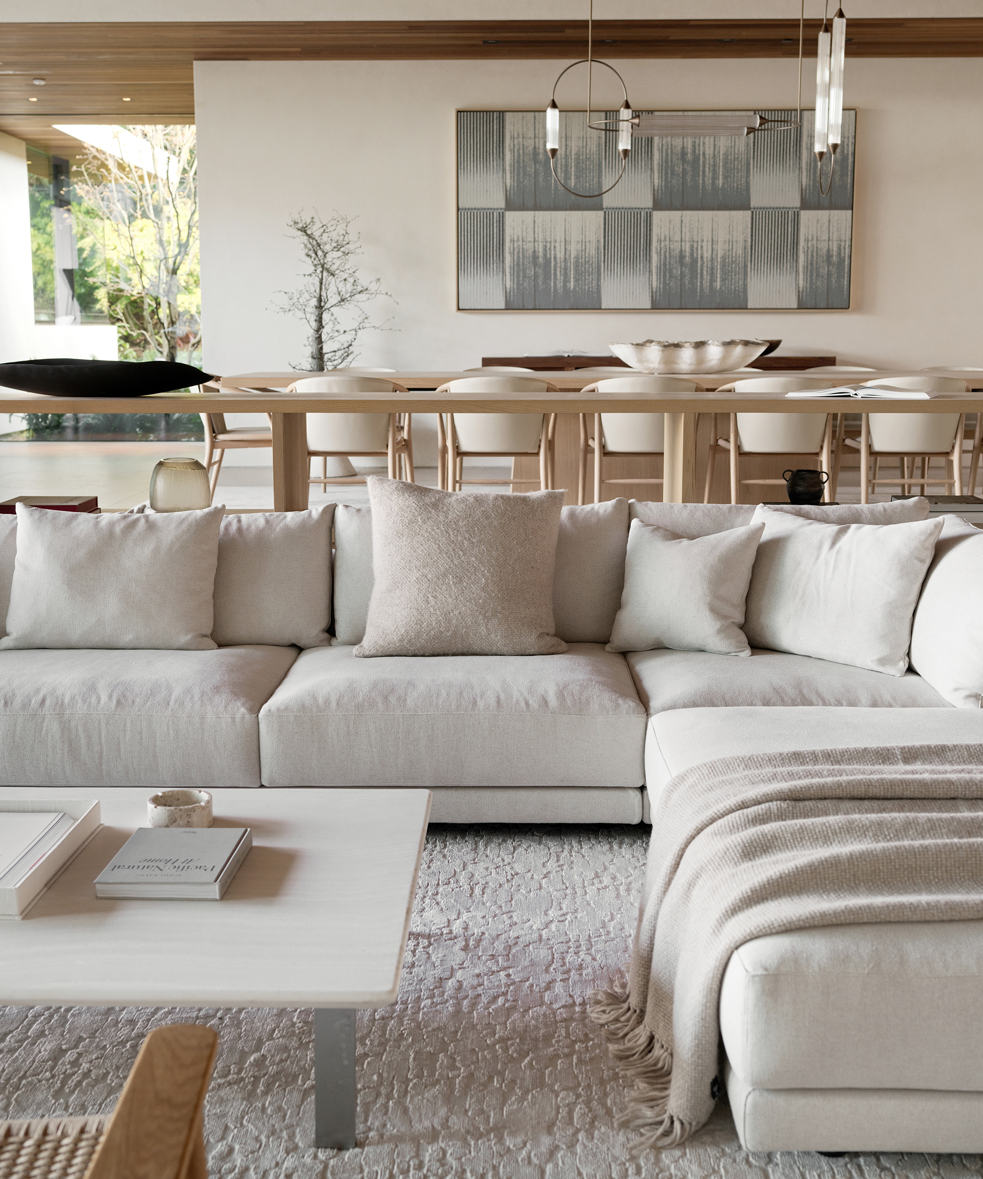 an ivory sectional with a taupe alpaca basketweave pillow and throw