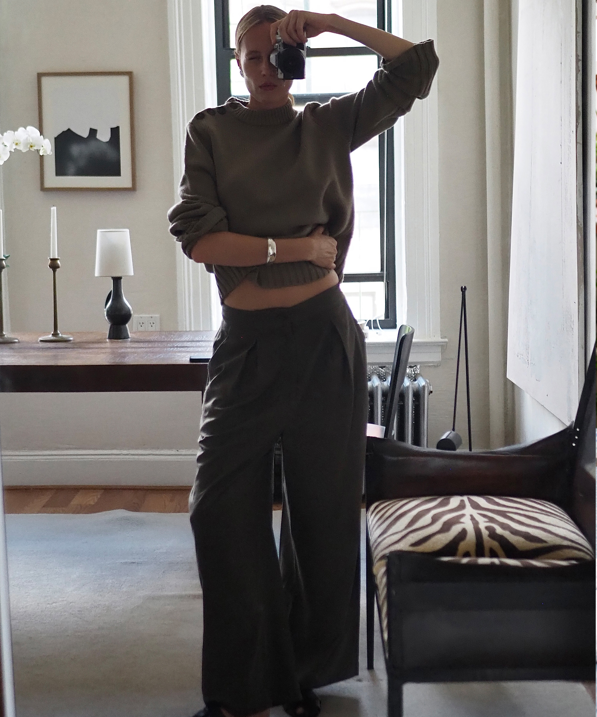 elly mcgaw in an umber cashmere sweater and relaxed trousers taking a self portrait in a mirror