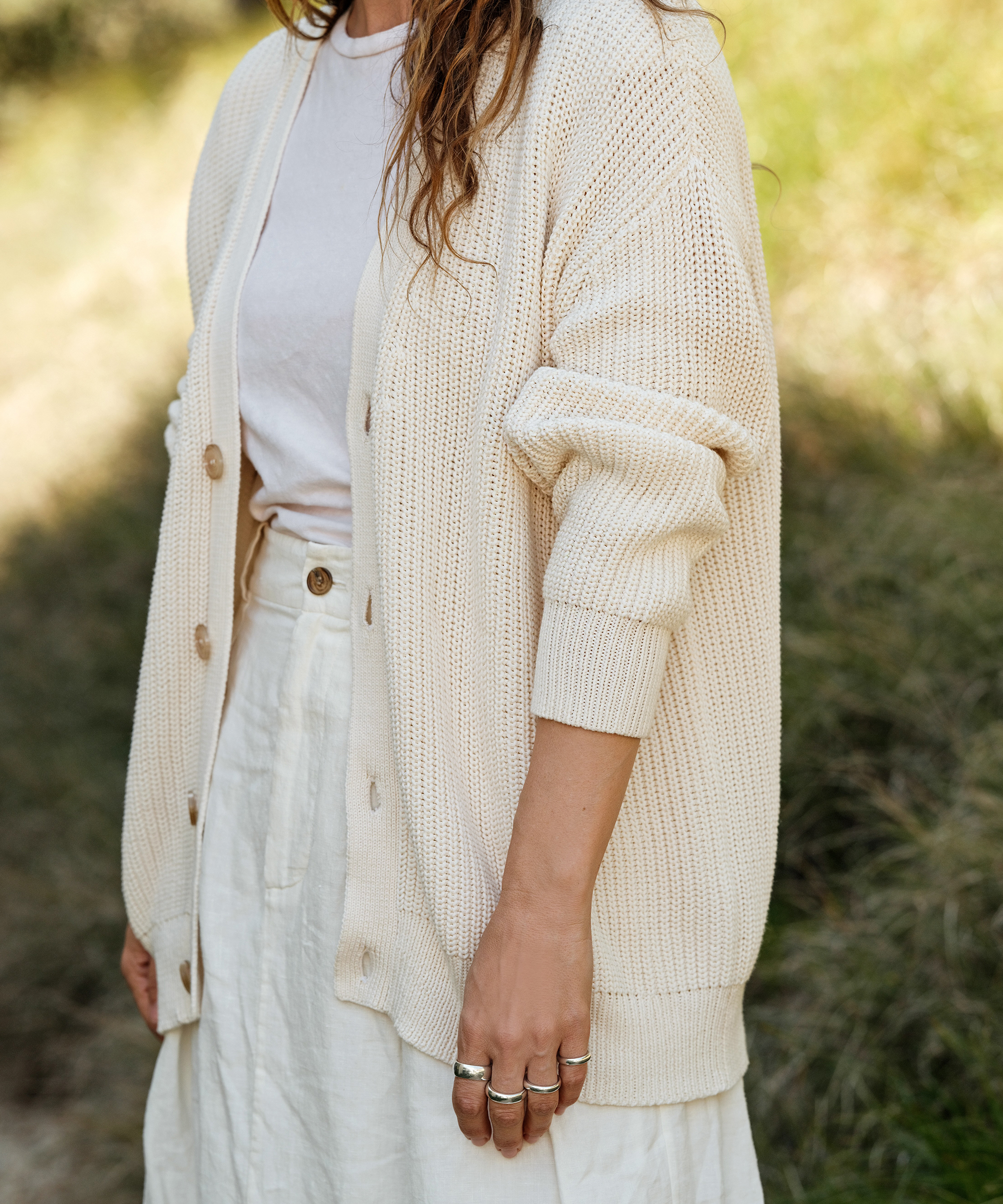 jenni in an ivory linen skirt and a white tee with an ivory cocoon cardigan