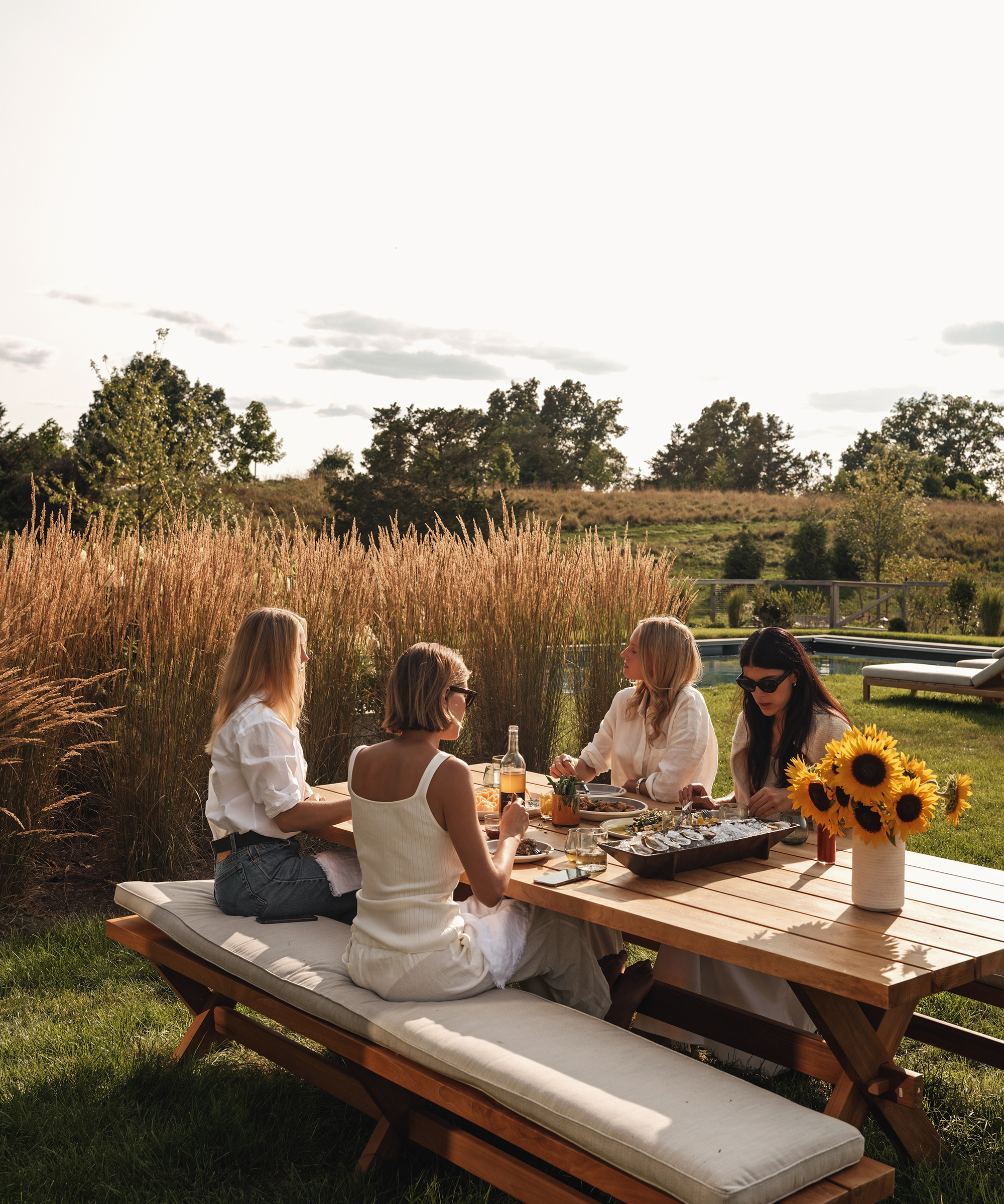an outdoor dining table with four women sitting around