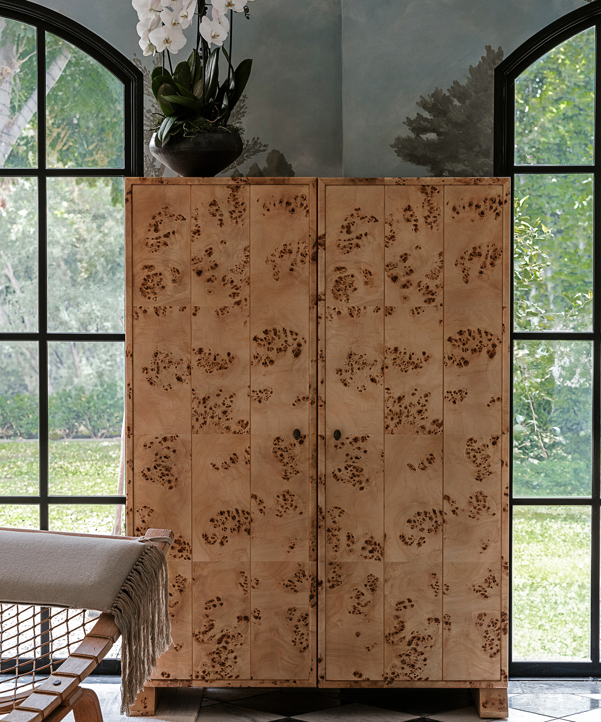 a hutch in a room between two floor to ceiling windows