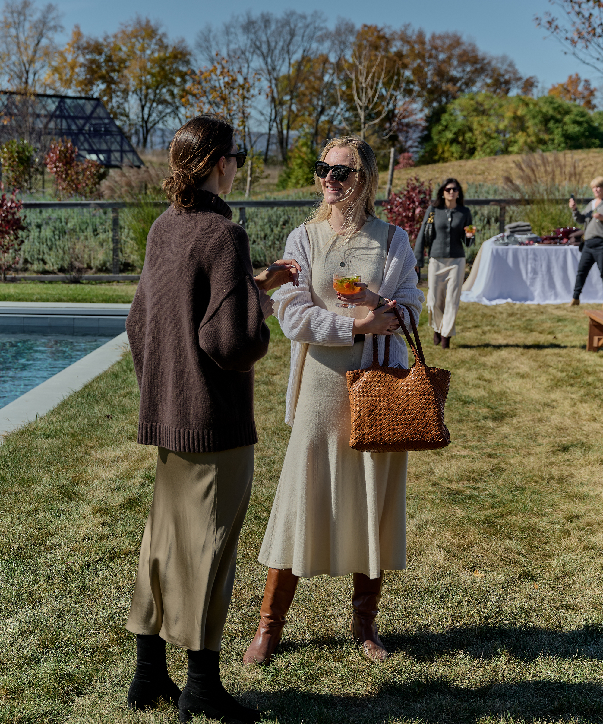 two women chatting outside in a dress and sweater