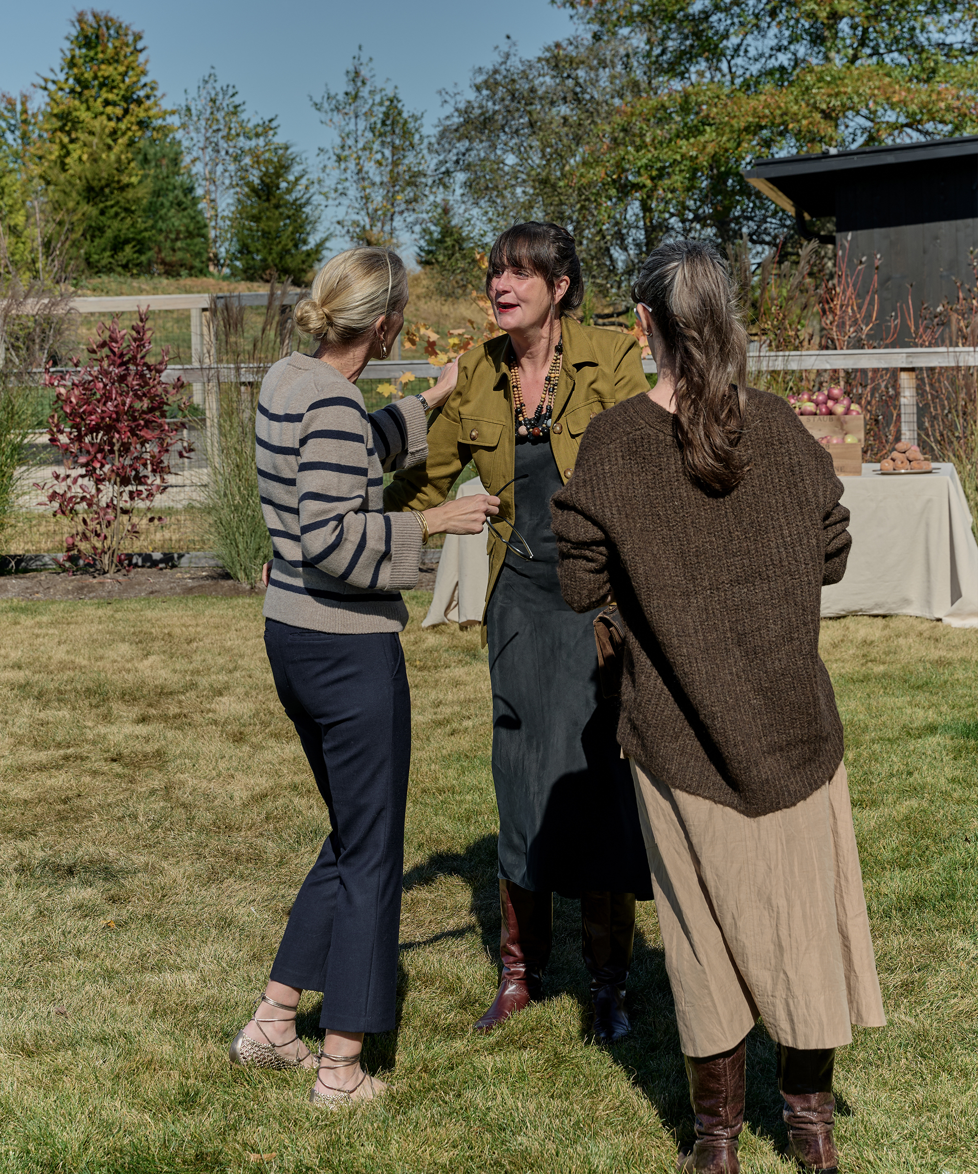 three women chatting outside in the grass