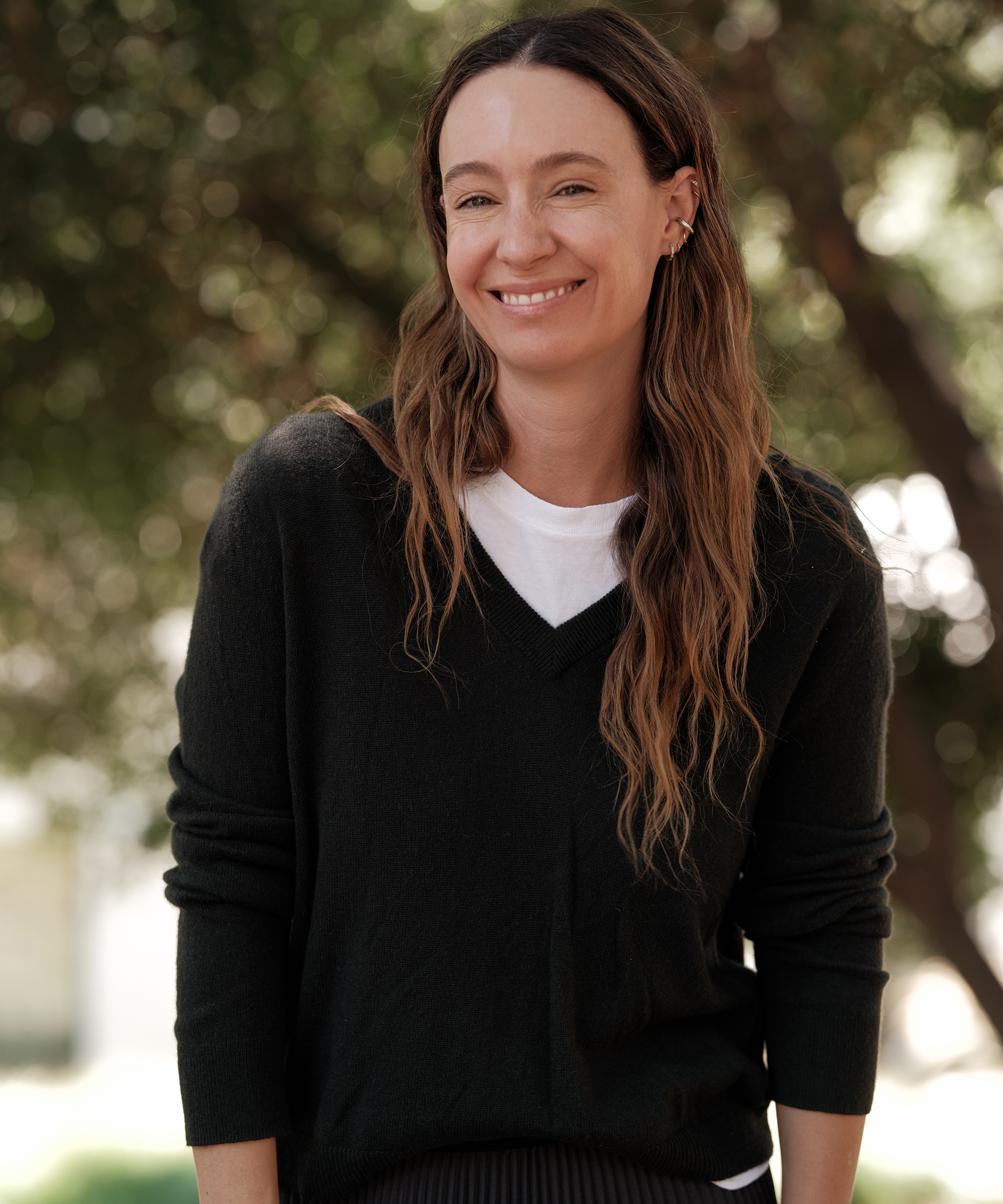 jenni wearing a forest green vneck sweater with a white tee underneath