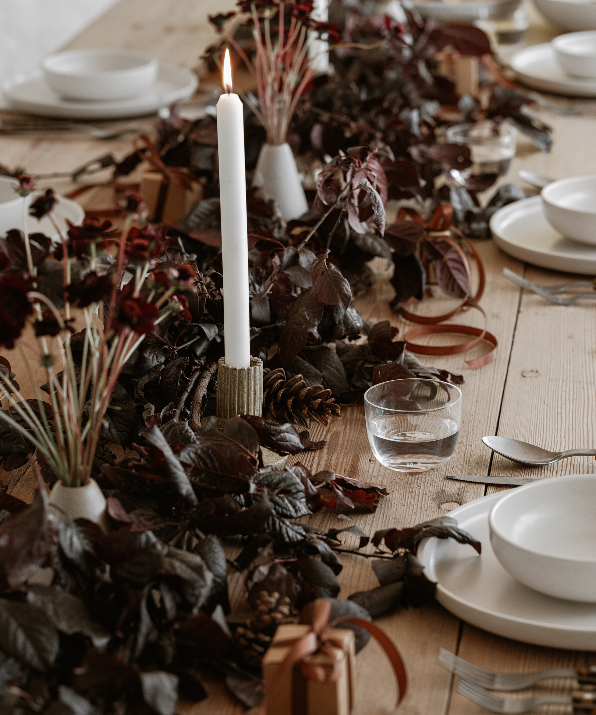 a table with dark florals and lit candles