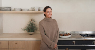 jenni standing in her kitchen wearing a cashmere taupe turtleneck