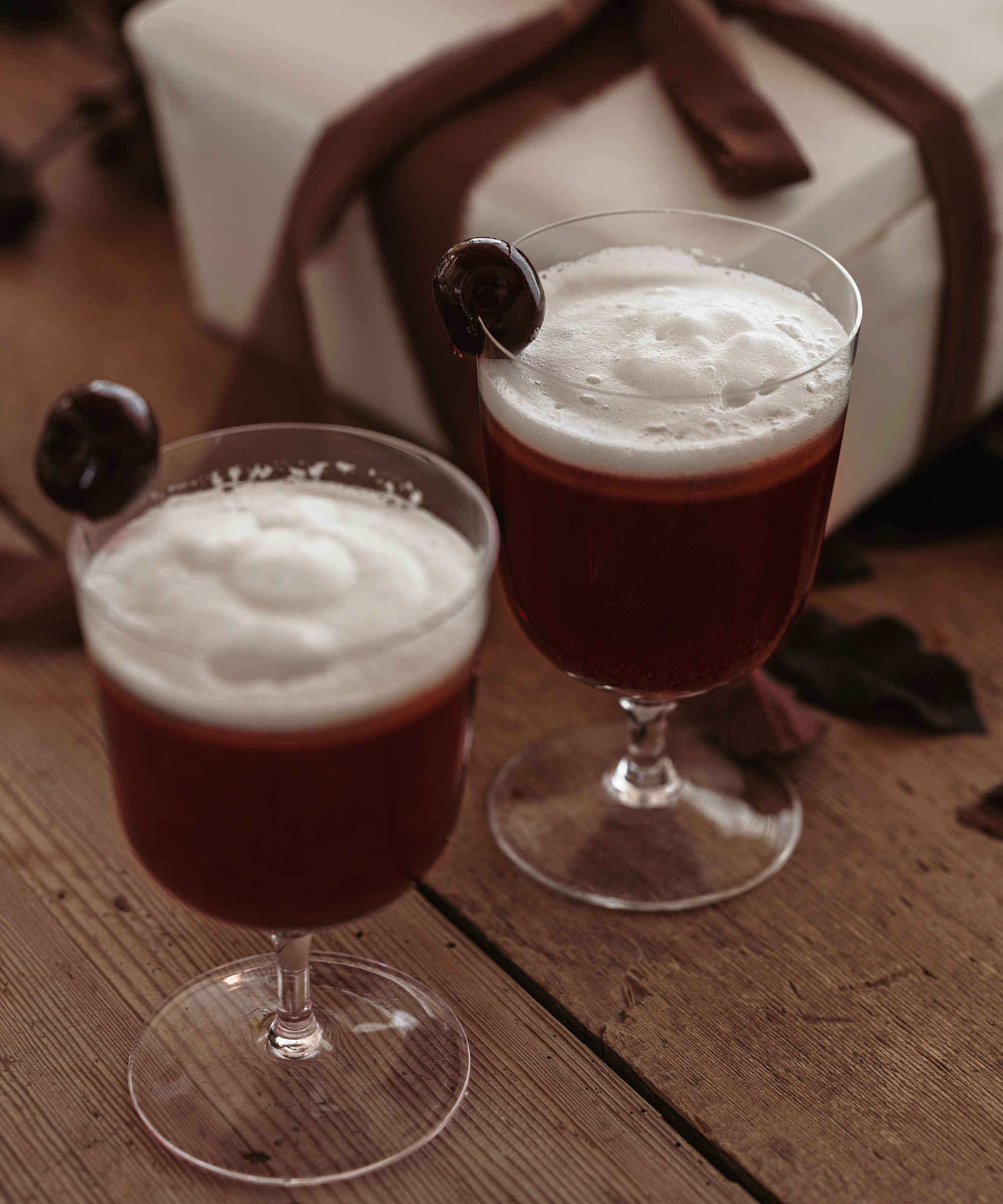 two glasses filled with dark cocktails