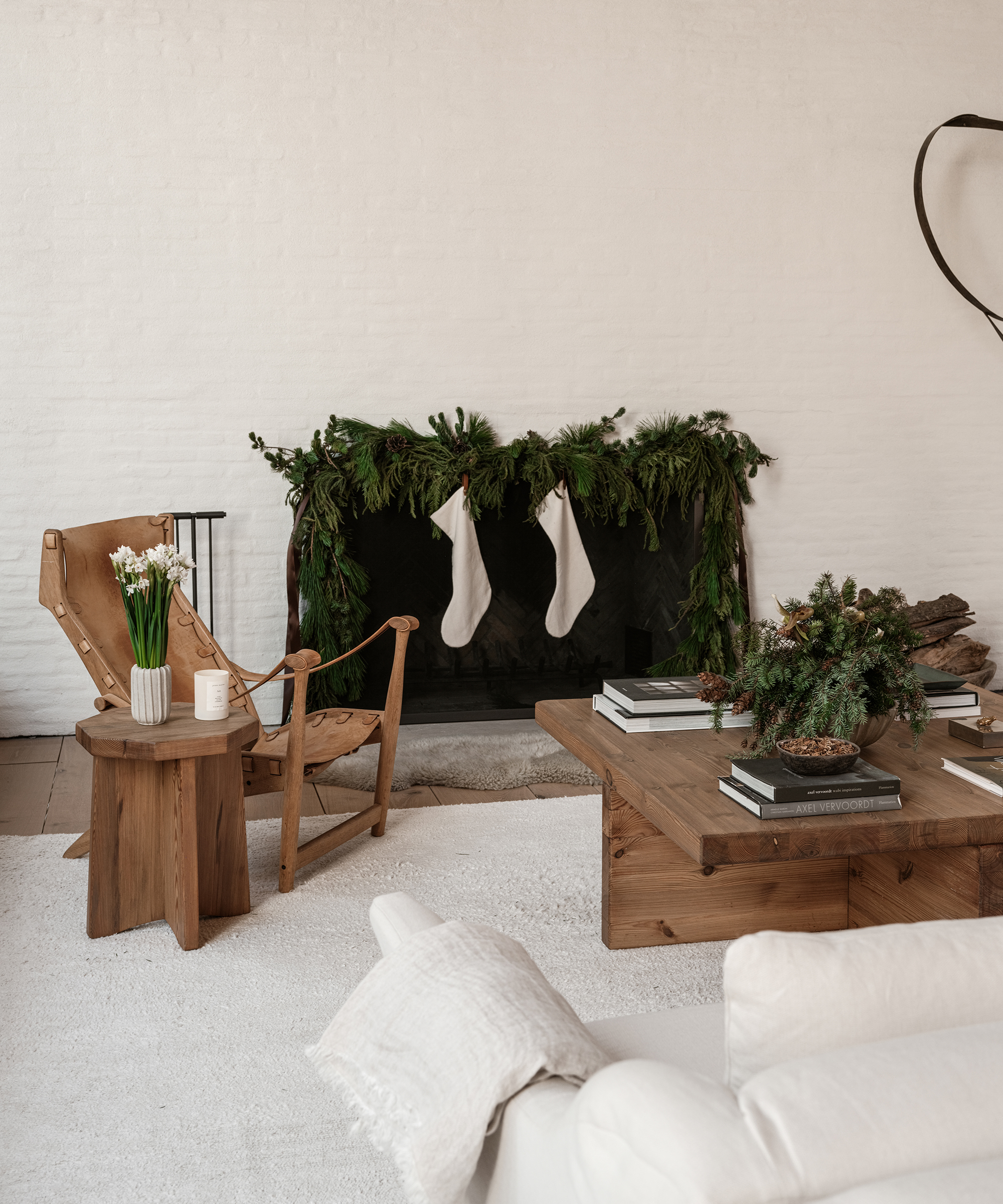 a living room with ivory bricks and a leather chair decorated with green garland