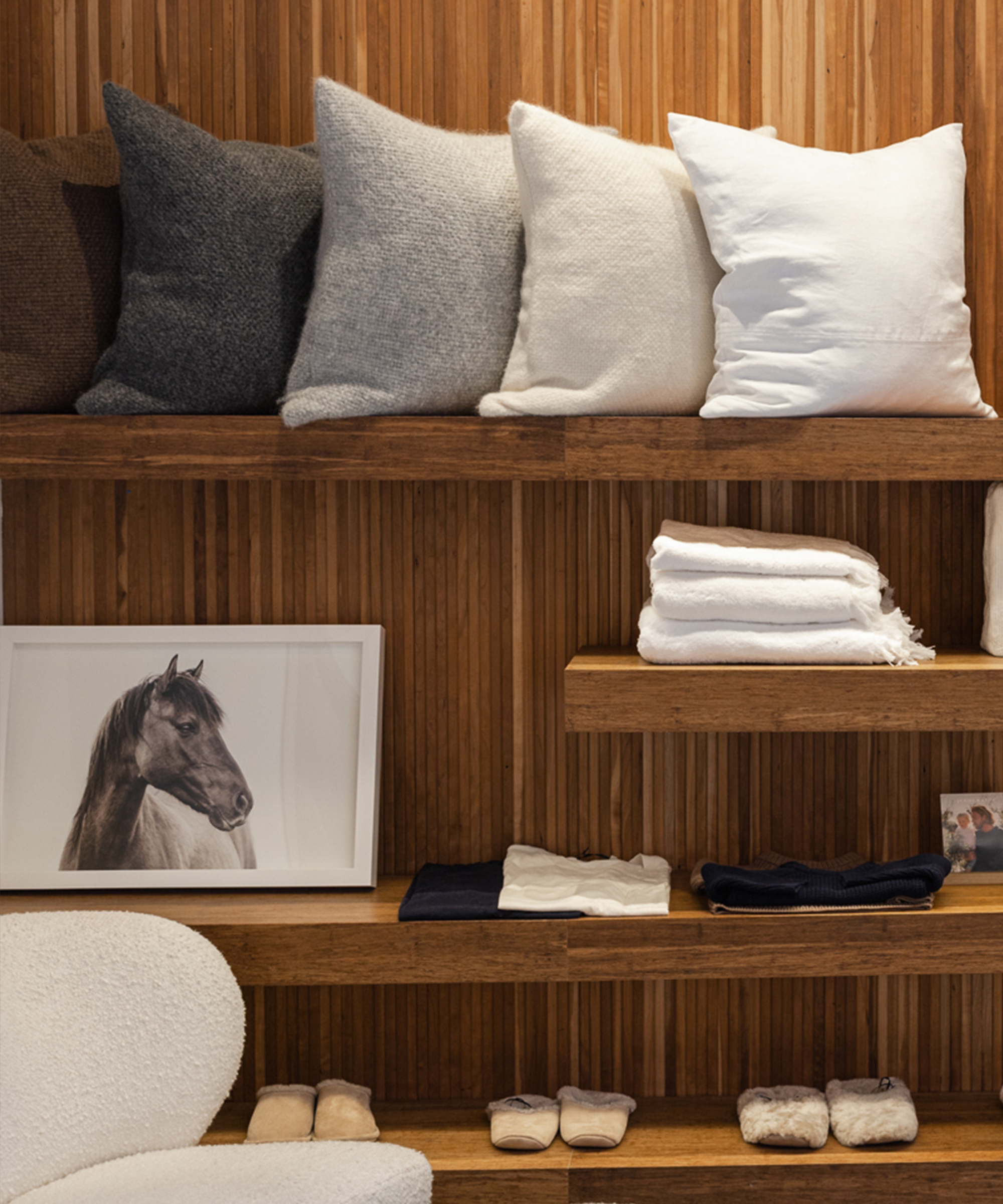 a wooden wall with accent pillows and a photograph framed in white