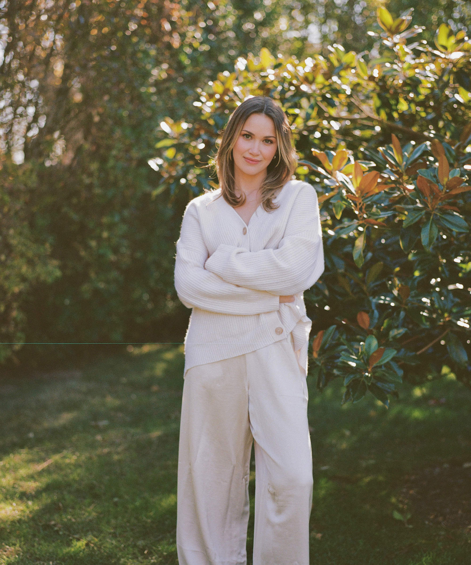 silk ivory pants and an ivory cashmere cocoon in a backyard
