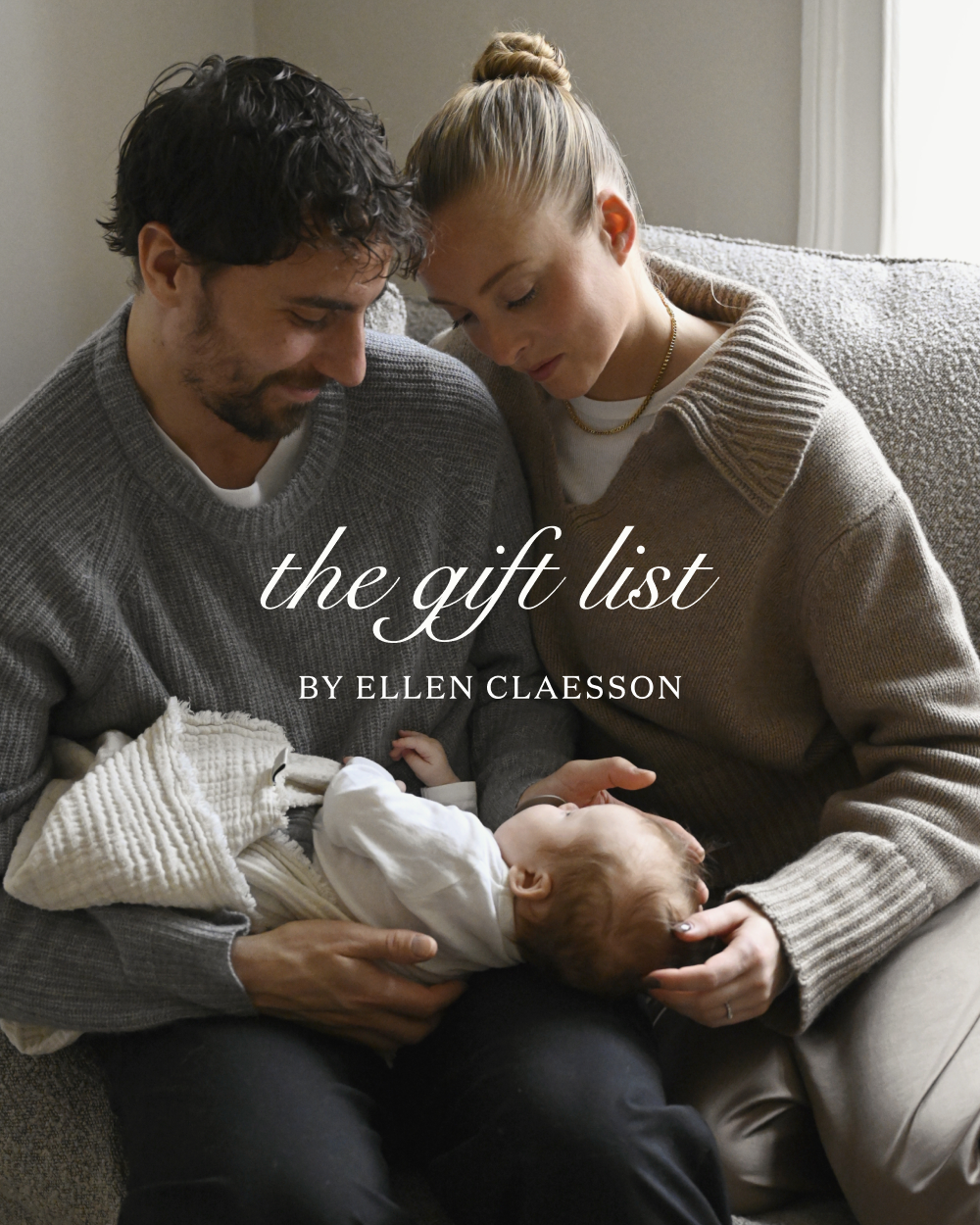 a couple wearing jenni kayne sweaters sitting on a couch holding their baby