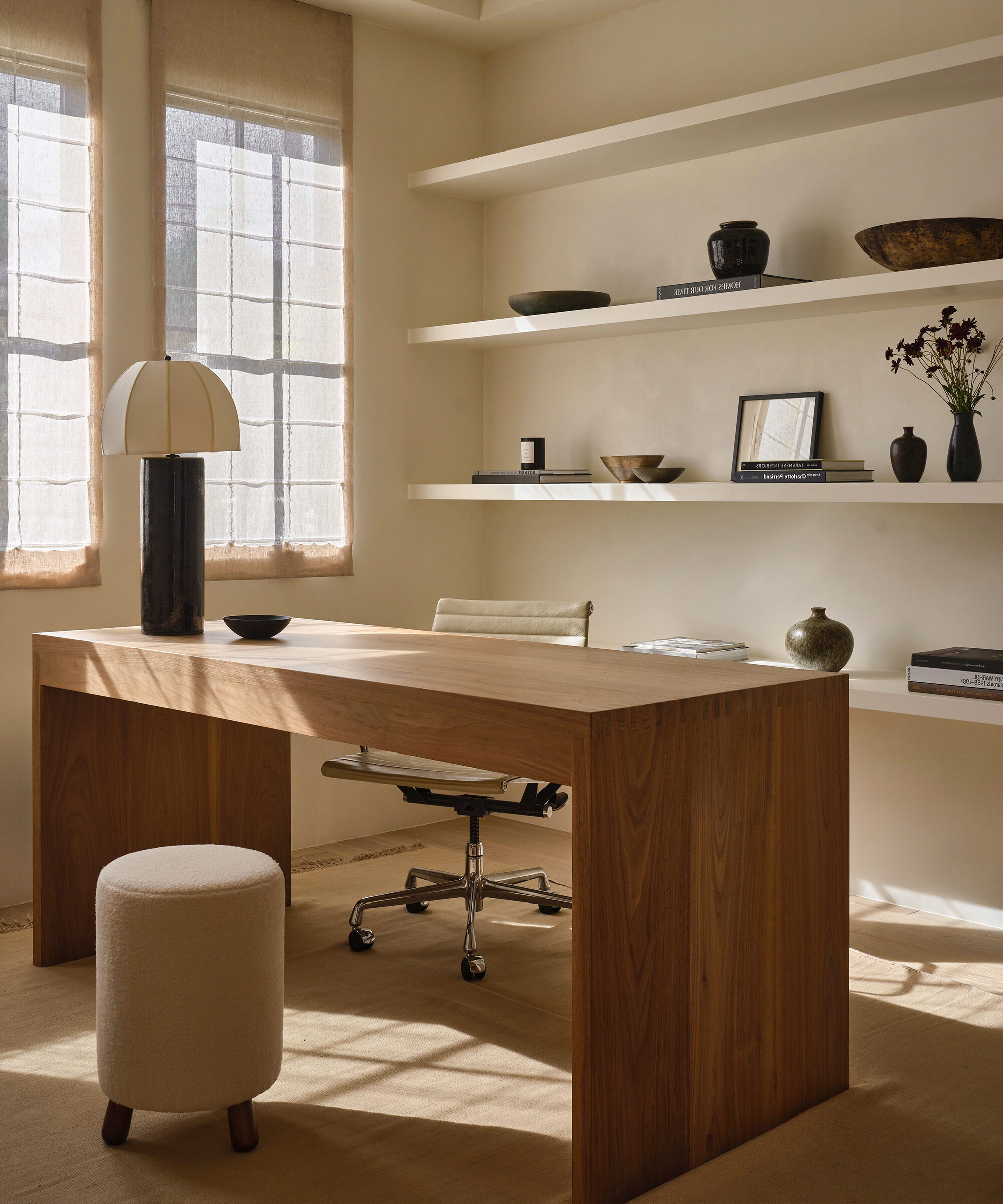 an office with an oak desk and black table lamp with open shelving