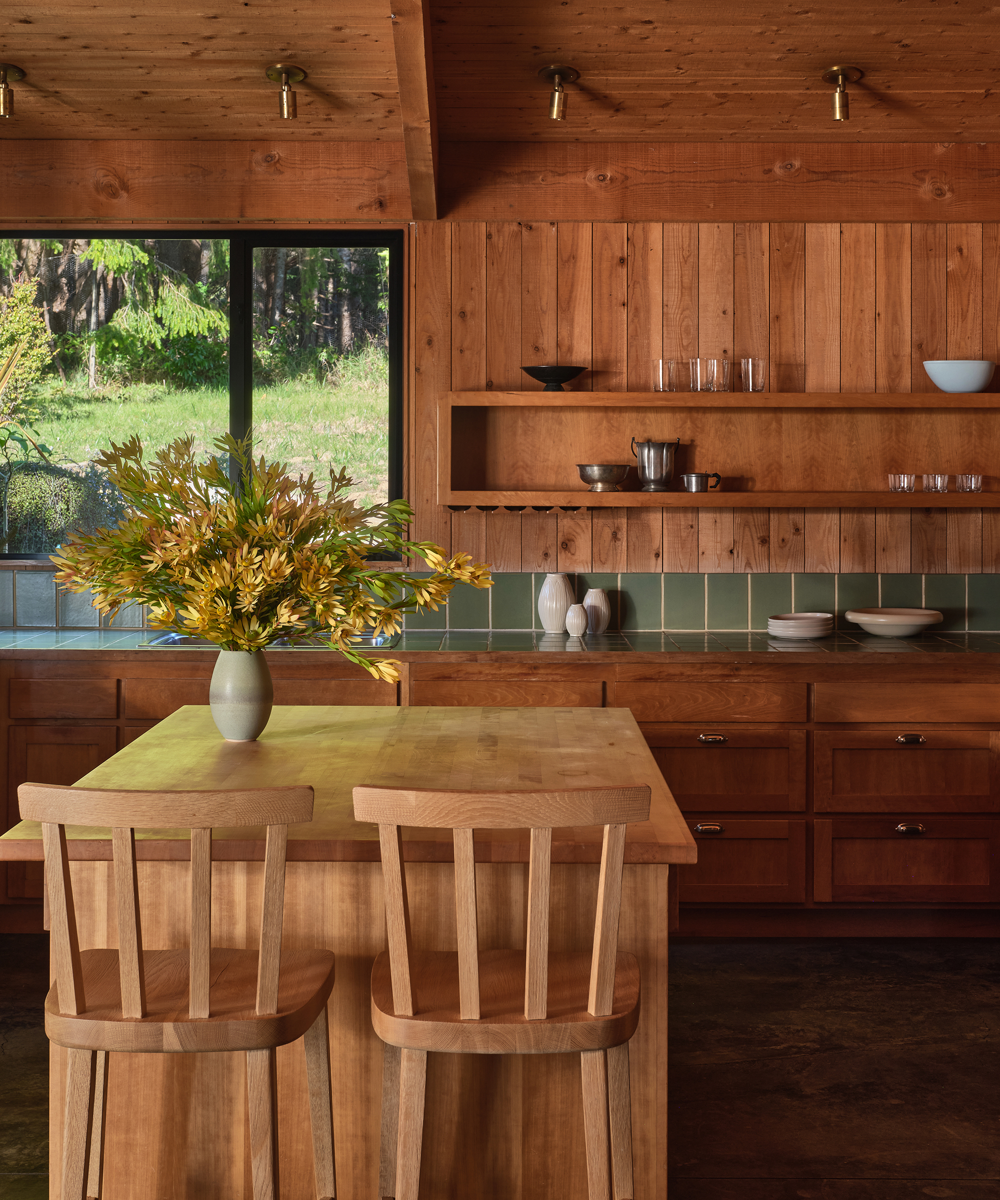 a kitchen with wooden paneling and green tile