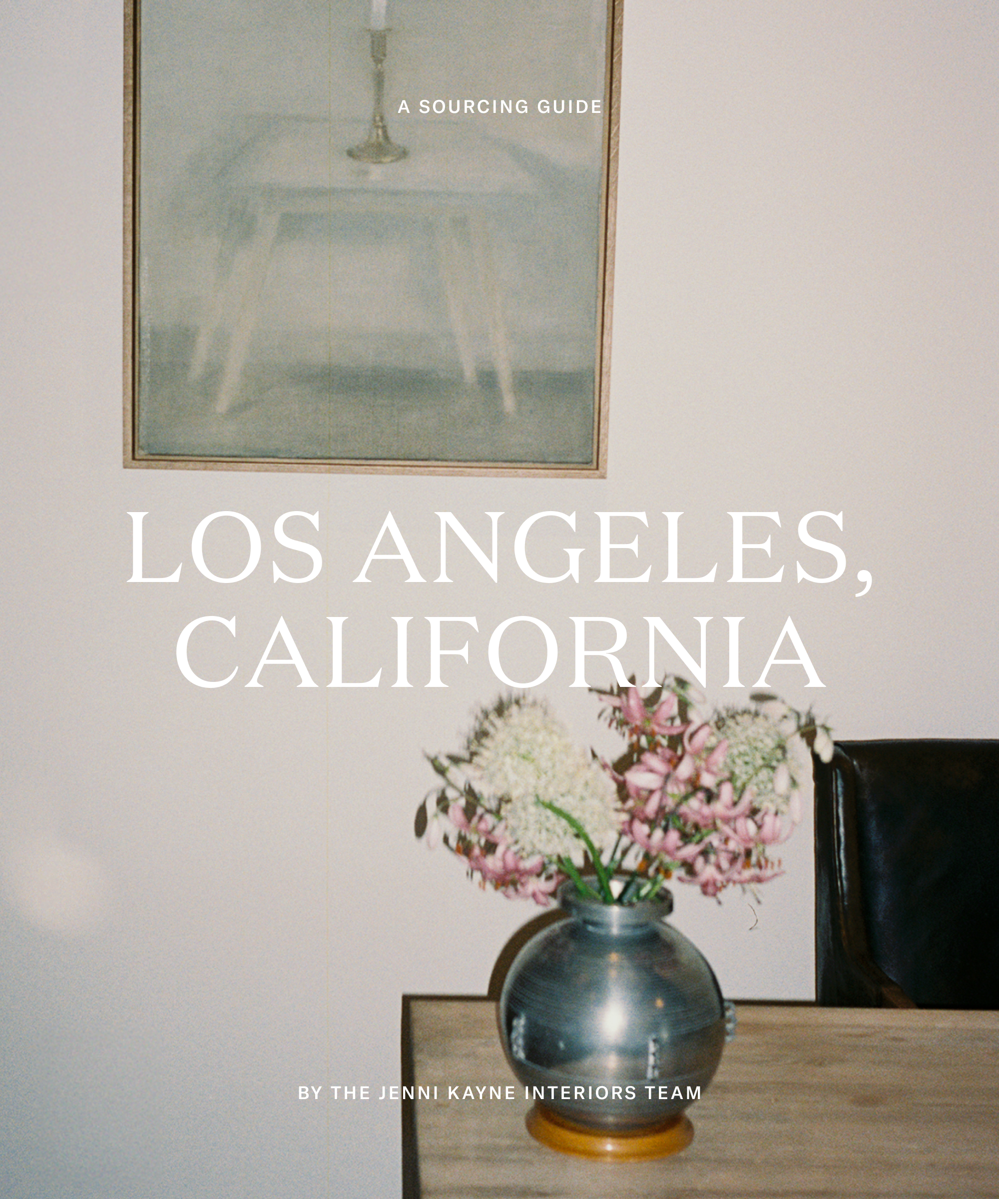 an image of a silver vase with florals in front of an acrylic painting on a creme wall