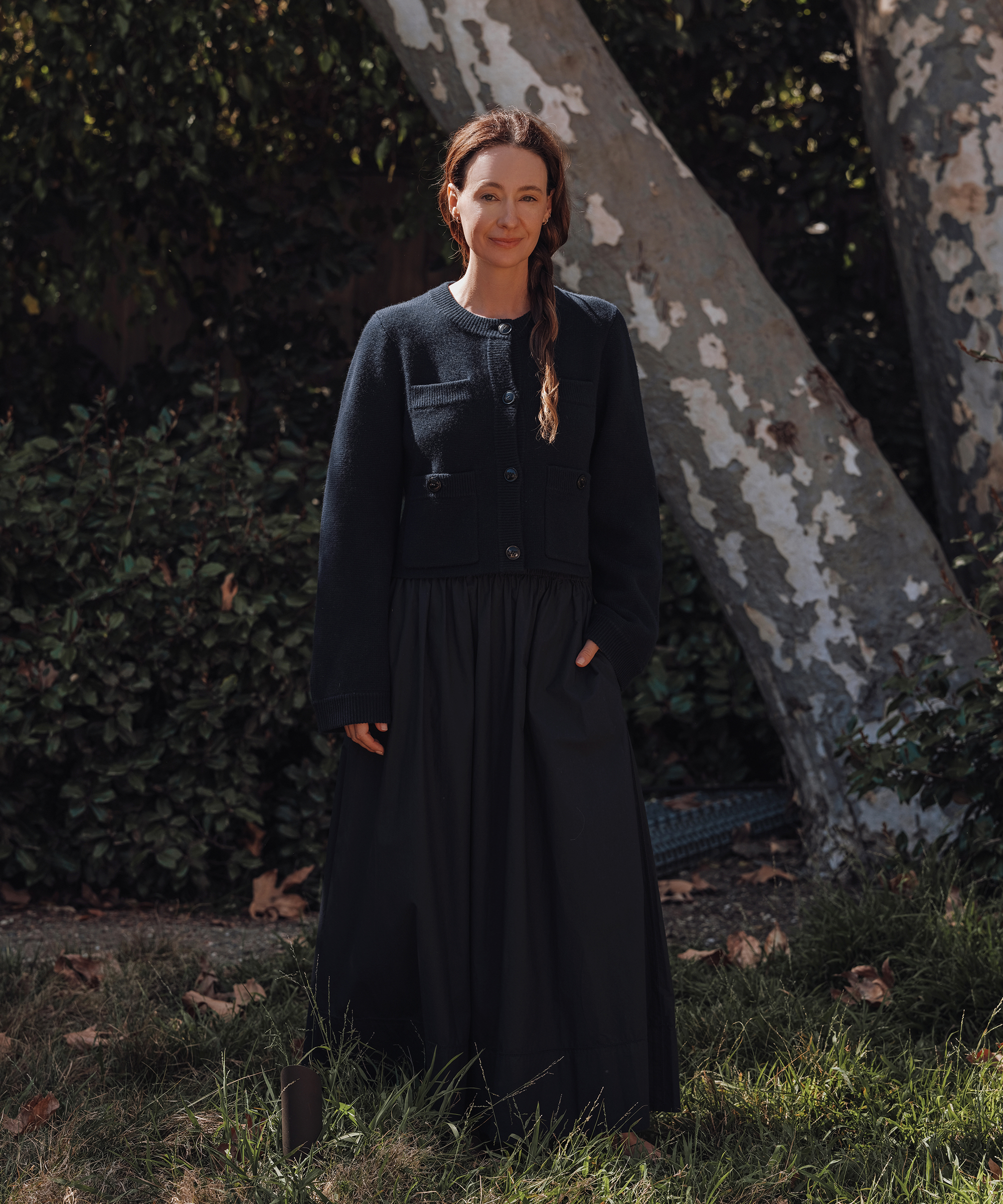 jenni wearing a navy structered sweater and navy maxi skirt outside by a tree