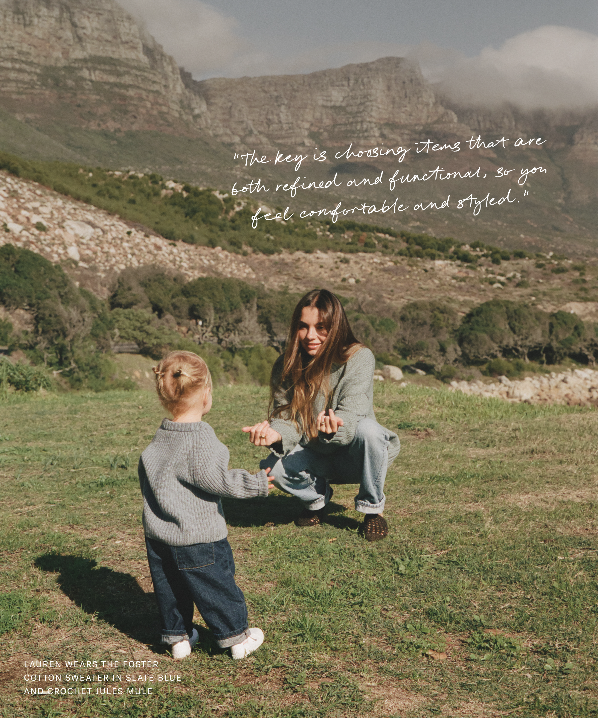a mom and daughter playing outside in jeans and cashmere sweaters in front of mountains