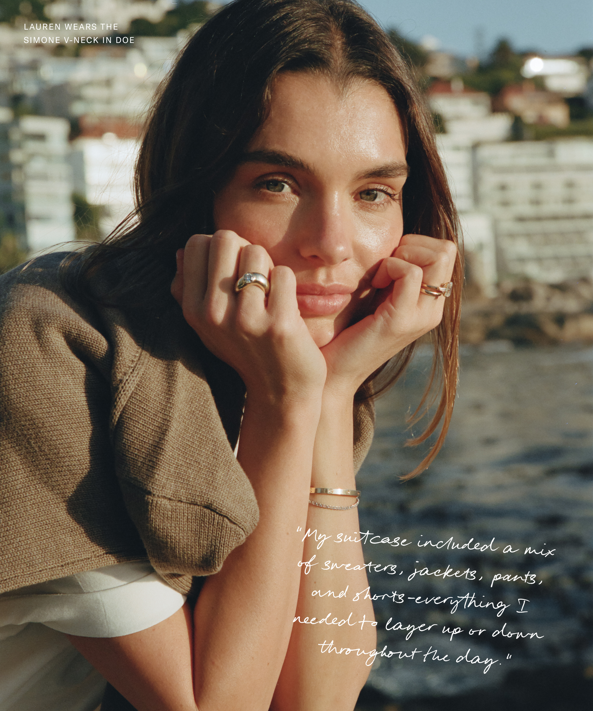 a portrait of lauren wearing white tee with a doe colored sweater next to the ocean