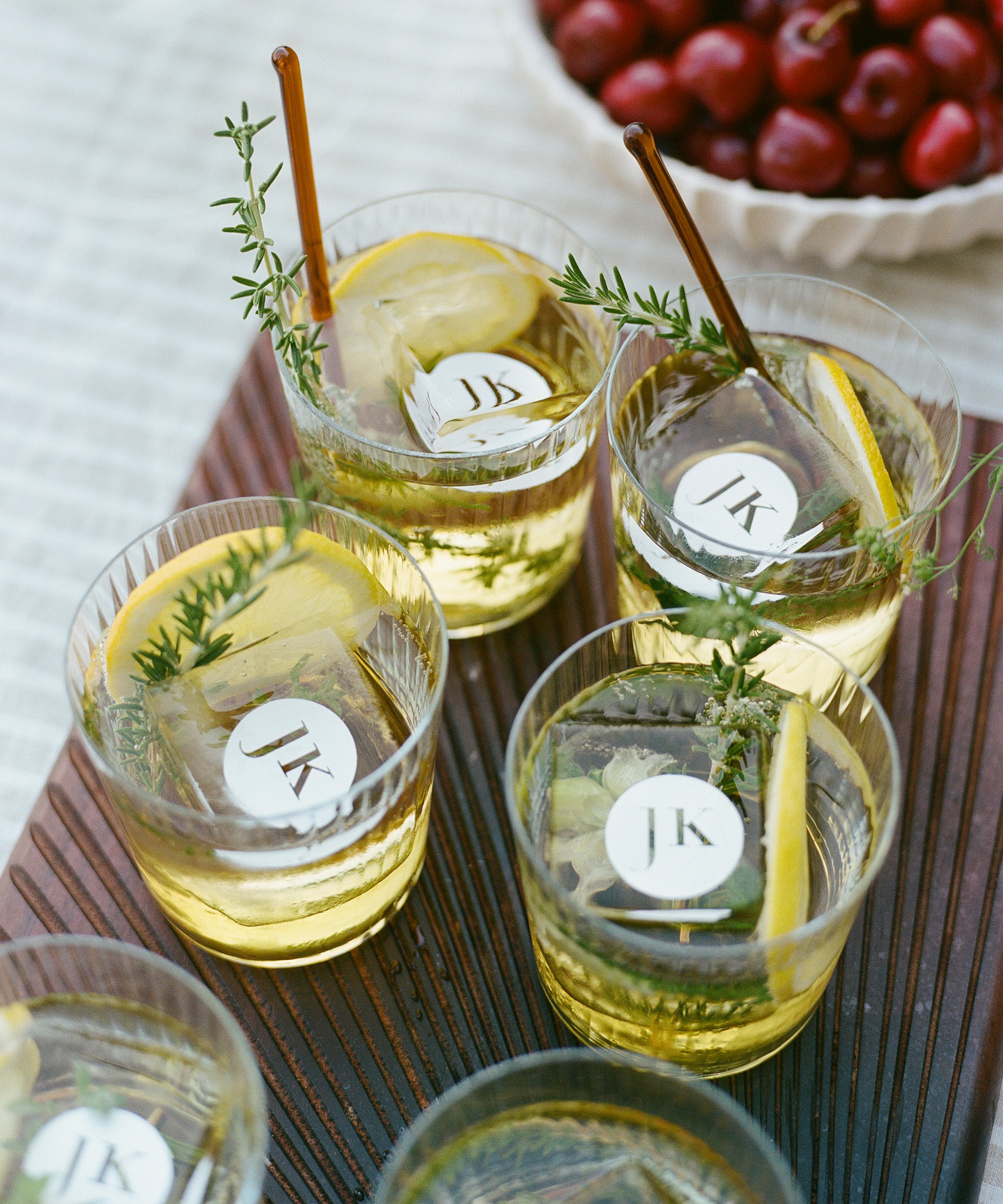 clear ribbed cocktail glasses on a wooden tray with cocktails and custom ice cubes