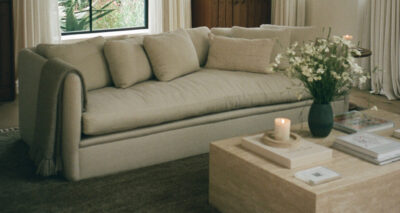 a living room with a dume sofa and travertine coffee table