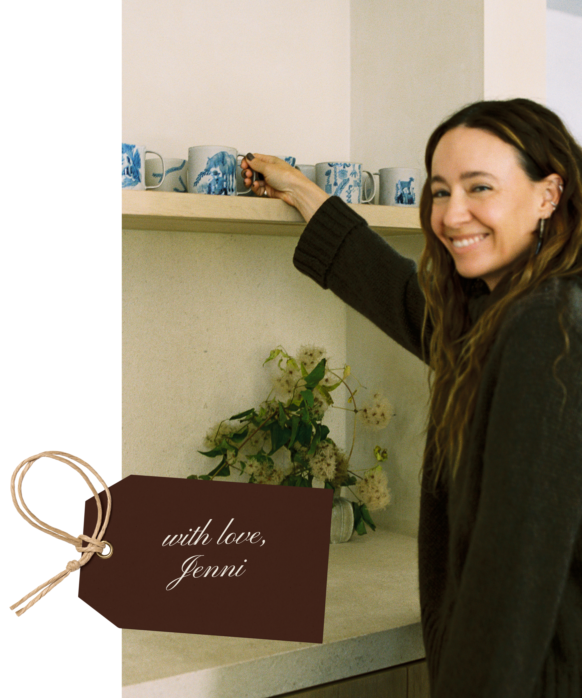 A smiling woman with long hair reaches for a mug on a kitchen shelf. Below, a bouquet of flowers sits on the counter. In the foreground, a brown gift tag reads with love, Jenni.