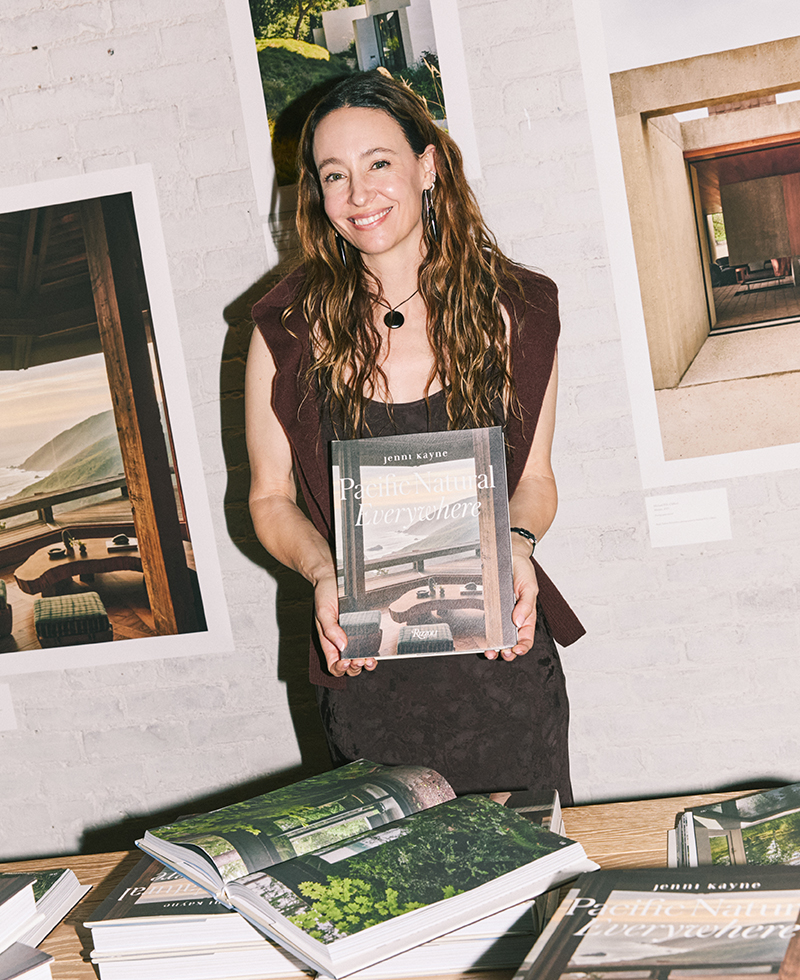 jenni wearing a chocolate dress holding a coffee table book
