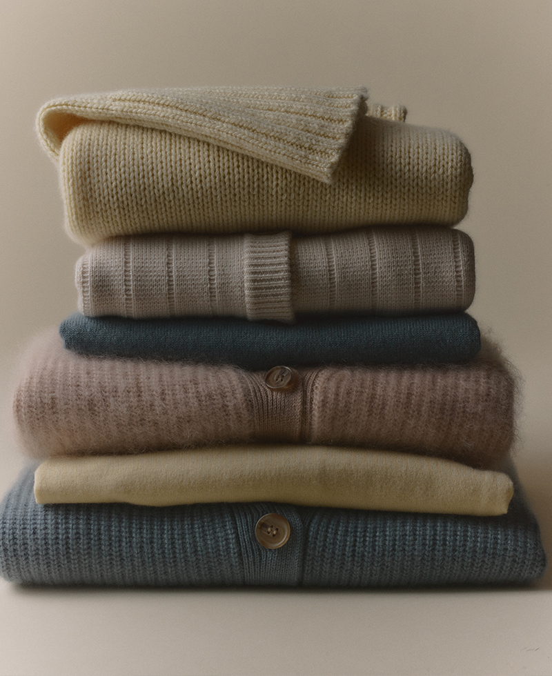 a stack of sweaters with varying colors